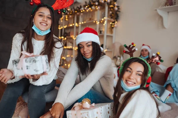 Multiethnic group of friends in Santa hats with gifts in hands. — Stock Photo, Image