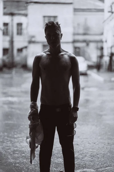 Porträtt av bekymmerslös stilig ung man känner sig fri under regnet — Stockfoto