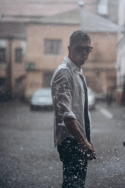 Portret van een zorgeloze knappe jongeman voelt zich vrij onder de regen — Stockfoto