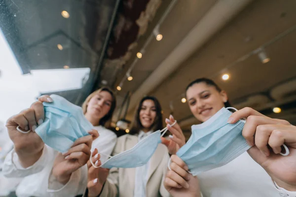 Mulheres brancas tirando uma máscara médica em um café — Fotografia de Stock