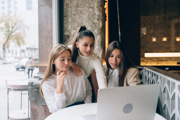 Группа подруг в кафе смотрит на ноутбук — стоковое фото