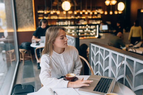 Giovane signora che naviga in Internet al caffè — Foto Stock