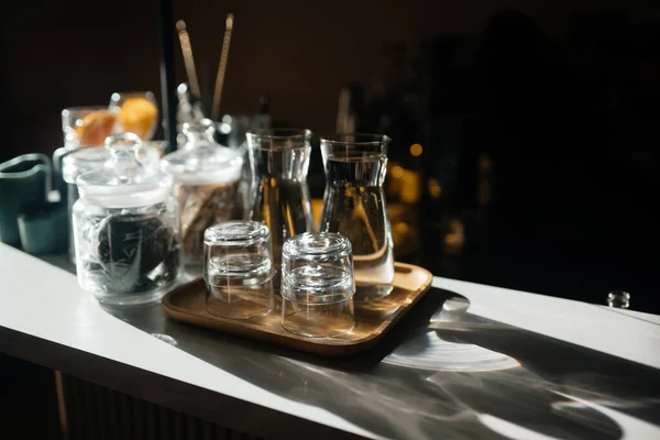 Fyra glas koppar på bardisken med serveringstillbehör. — Stockfoto