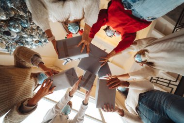 Çok ırklı arkadaşlar Noel hediyelerini havaya fırlatıyorlar..