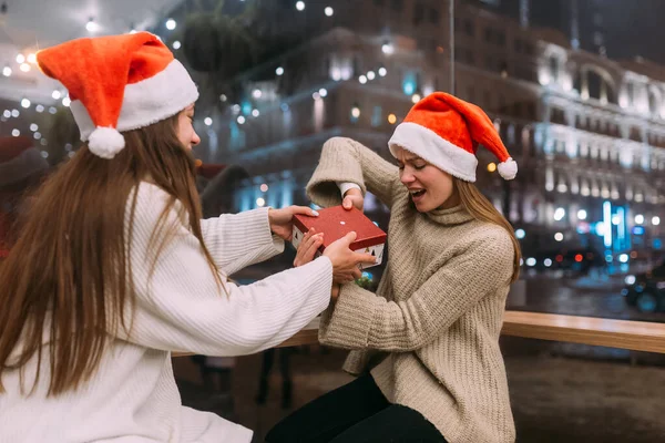 Flickor slåss om en present på caféet. Vänner kul på café — Stockfoto