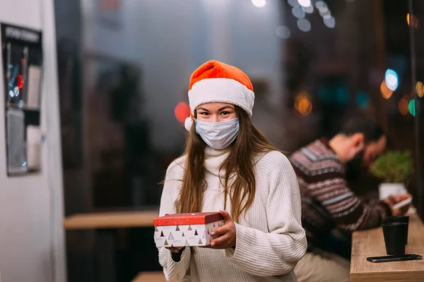 행복 한 젊고 아름다운 여성의 초상화 선물 상자를 들고 카페에서 미소짓는 모습. — 스톡 사진