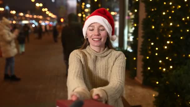 Jovem mulher dando caixa para você ao ar livre. Conceito de troca de presentes. — Vídeo de Stock