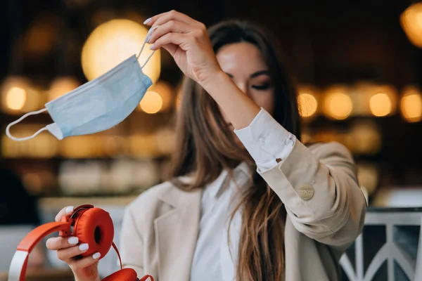 Dívka v kavárně, sundá si ochrannou masku. — Stock fotografie