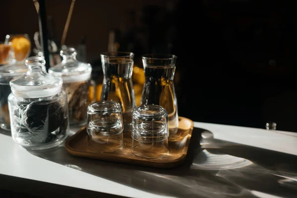 Cuatro vasos de vidrio en el mostrador de la barra con accesorios para servir. —  Fotos de Stock