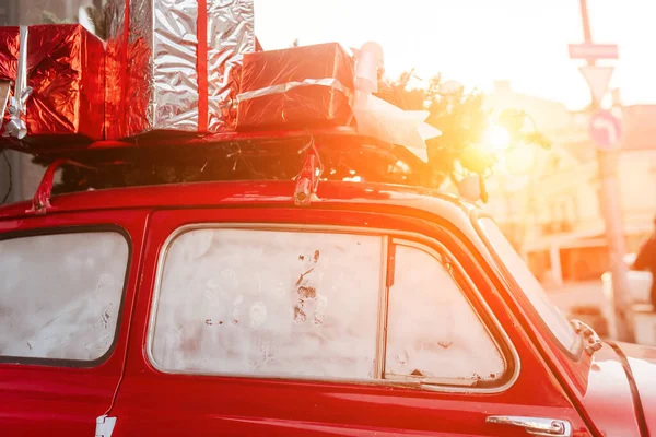 Red retro car with a Christmas tree fir tied to the roof. — Stock Photo, Image