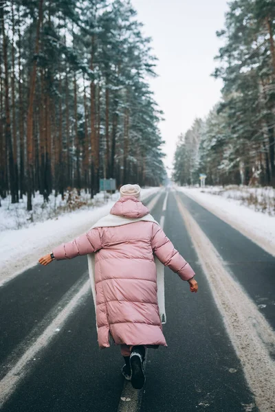 Porträtt av en vacker kaukasisk kvinna på en väg genom snöig skog — Stockfoto