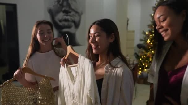 Attractive young women in pajamas is choosing clothes in room — Stock Video