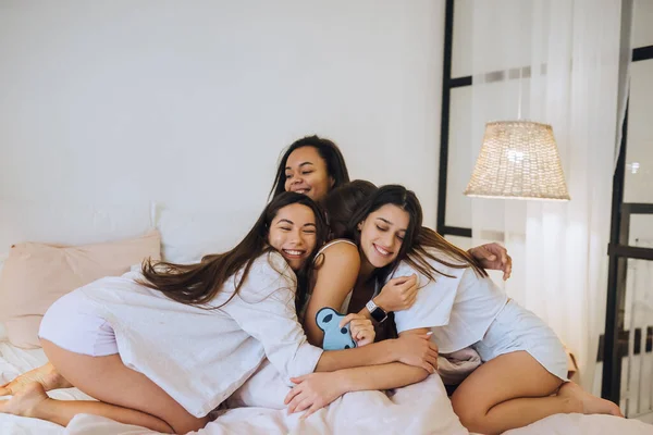 Chicas jóvenes positivas mujeres amigos en el interior de la cama en la despedida de soltera en casa. —  Fotos de Stock