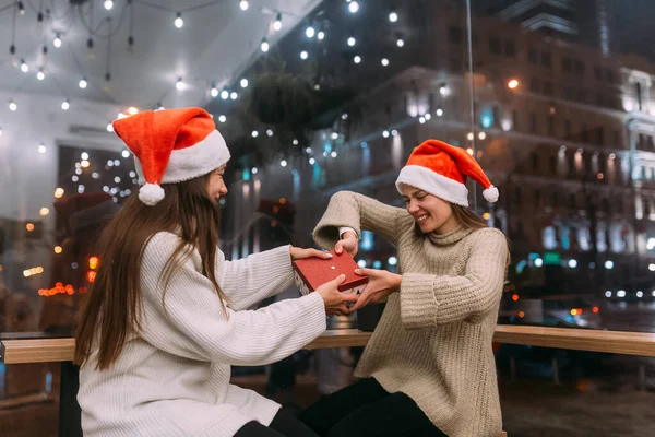 As meninas lutam por um presente no café. Amigos diversão no café — Fotografia de Stock