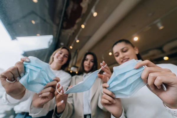 Mulheres brancas tirando uma máscara médica em um café — Fotografia de Stock