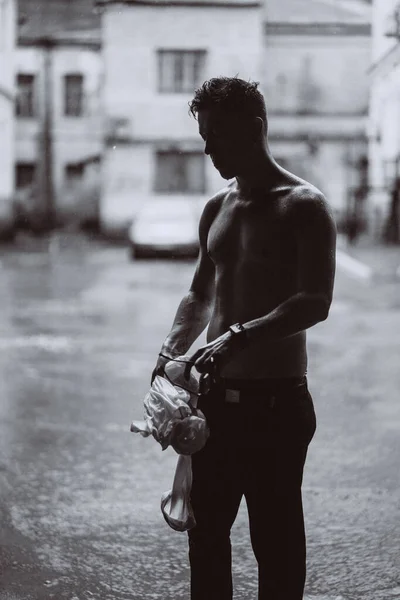 Портрет беззаботного красивого молодого человека чувствует себя свободным под дождем — стоковое фото