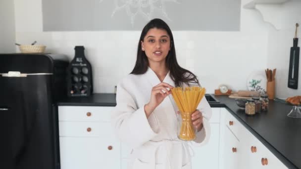 Menina sorridente bonita vestida com roupão branco preparando café da manhã. — Vídeo de Stock