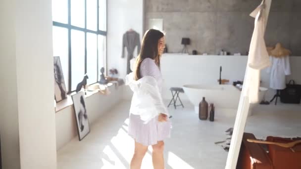 Mooi meisje proberen jurk in kamer — Stockvideo
