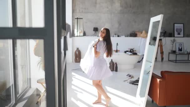 Gyönyörű lány kipróbálás ruha a szobában — Stock videók