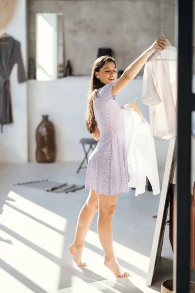 Beautiful girl trying dress in room — Stock Photo, Image