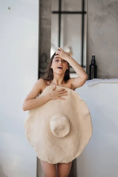 Bella giovane donna copre il suo corpo con un grande cappello. — Foto Stock