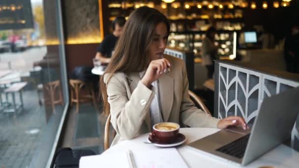 Jonge dame surfen op het internet in het cafe — Stockvideo