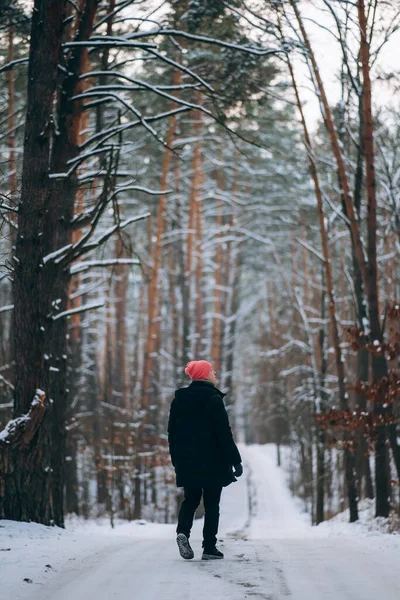 Man op de weg in het midden van het bos, omgeven door sneeuw — Stockfoto
