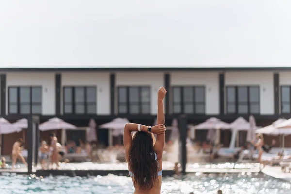 Mujer joven en el fondo de la piscina en un traje de baño blanco. —  Fotos de Stock