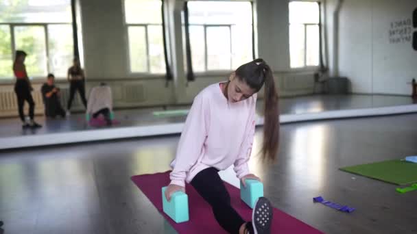 Porträtt av en ung kvinna som gör övningar på gymmet — Stockvideo