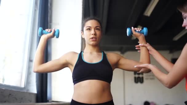 Νεαρή γυναίκα προσωπικός γυμναστής βοηθά με την προπόνηση στο γυμναστήριο — Αρχείο Βίντεο
