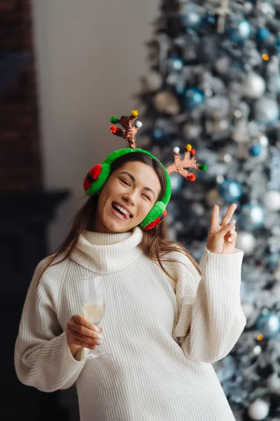 Vacker ung kvinna med ett glas champagne hemma. — Stockfoto