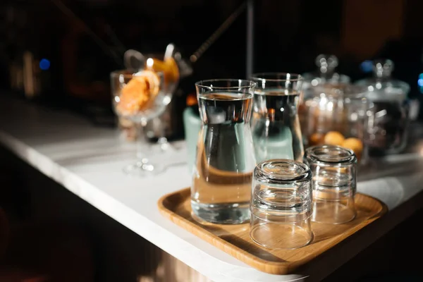 Quatre tasses en verre sur le comptoir du bar avec accessoires de service. — Photo