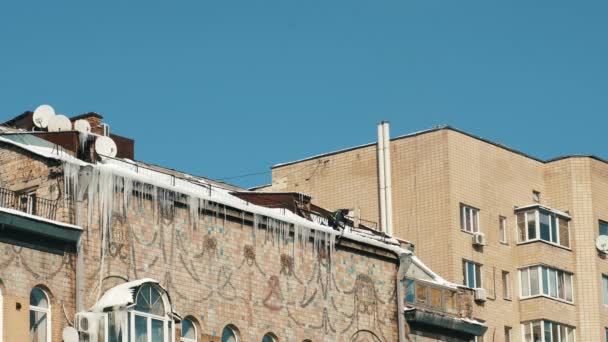 清除建筑物屋顶上冰块的人. — 图库视频影像