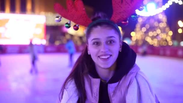 La gente disfruta patinaje sobre hielo en la calle alrededor del árbol de Navidad en pista de patinaje. — Vídeos de Stock