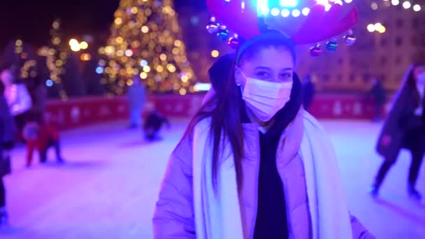 La gente disfruta patinaje sobre hielo en la calle alrededor del árbol de Navidad en pista de patinaje. — Vídeos de Stock