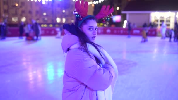 La gente disfruta patinaje sobre hielo en la calle alrededor del árbol de Navidad en pista de patinaje. — Vídeos de Stock