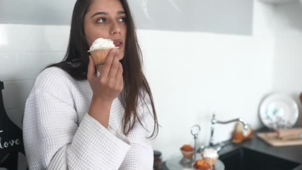 Linda noiva morena comer bolo em um roupão — Vídeo de Stock