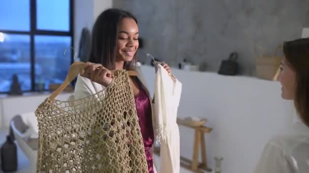 Attractive young women in pajamas is choosing clothes in room — Stock Video