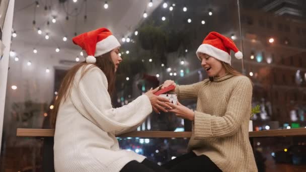 La fille donne un cadeau à son amie en caffe — Video