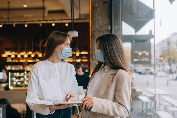 Dos empresarias con sus máscaras faciales debatiendo diferentes puntos de vista sobre el trabajo —  Fotos de Stock