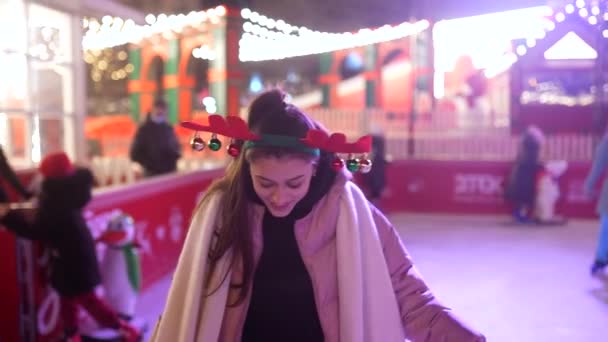 Les gens aiment patiner sur glace dans la rue autour de l'arbre de Noël dans la patinoire. — Video