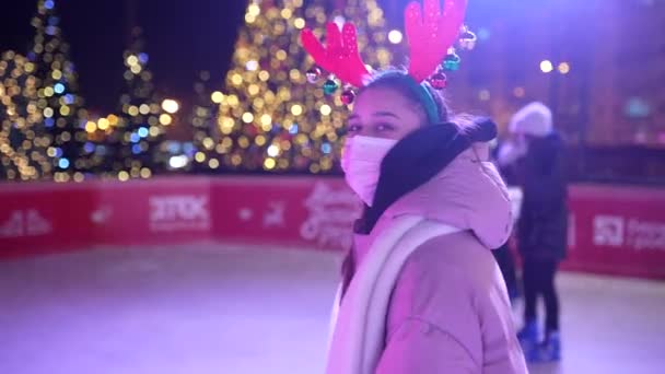 La gente disfruta patinaje sobre hielo en la calle alrededor del árbol de Navidad en pista de patinaje. — Vídeos de Stock