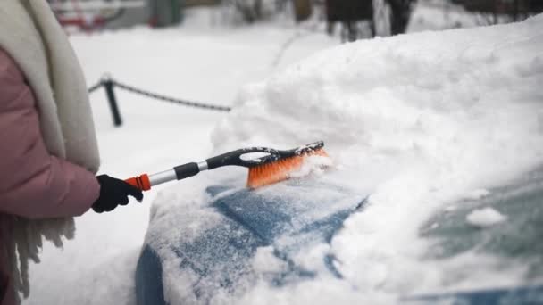 Wanita menghapus salju dari mobil — Stok Video