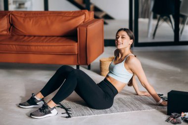 Güzel genç bayan evde egzersiz yapıyor.