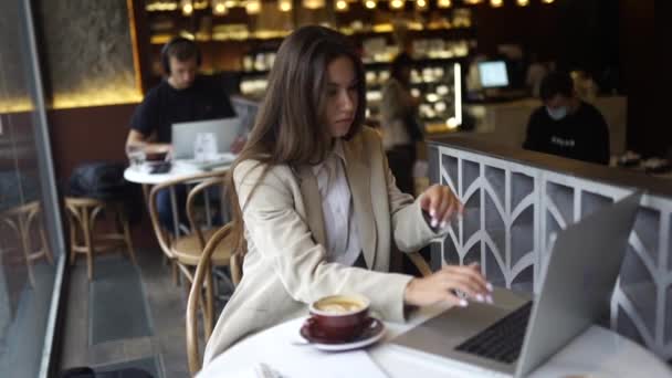 Jonge dame surfen op het internet in het cafe — Stockvideo