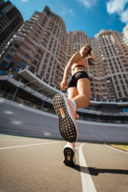 Genç, güzel, siyah saçlı, atletik bir kız, ısınıyor.