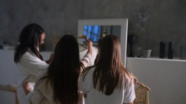 Pijamalı çekici genç kadınlar odadaki kıyafetleri seçiyor.