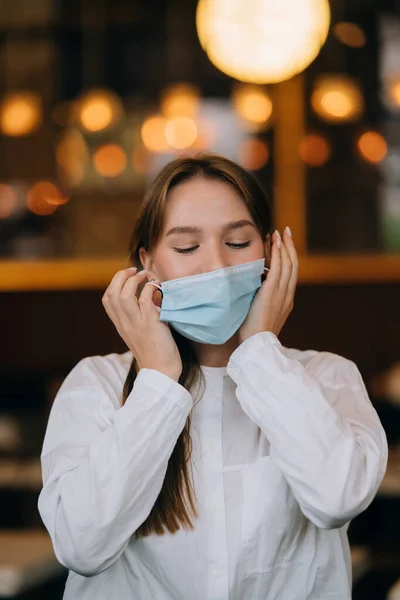 Девушка снимает свою защитную медицинскую маску — стоковое фото