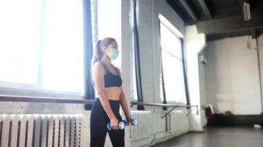 Spor salonunda egzersiz yapan genç bir kadının portresi.