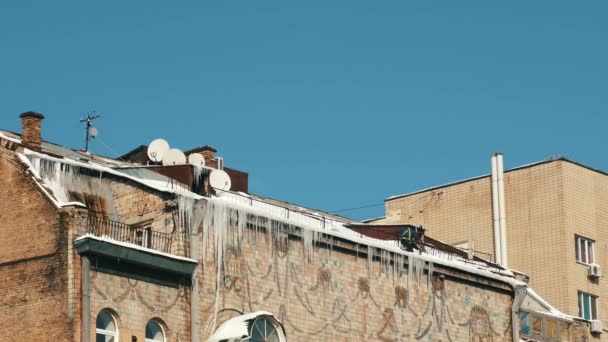Mann beseitigt Eis auf Hausdach. — Stockvideo